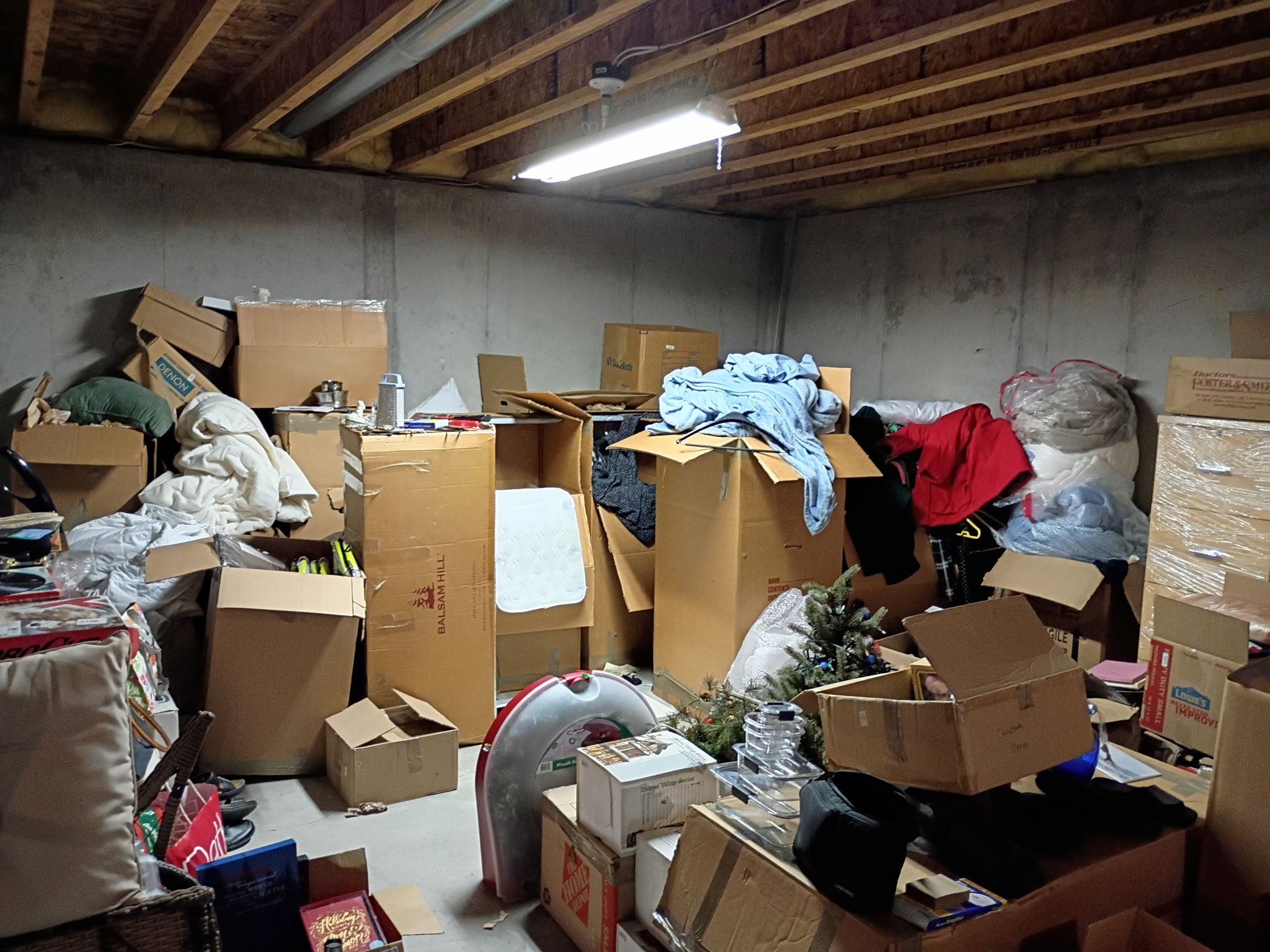 Basement packed with boxes and junk before cleanout in Northern Colorado