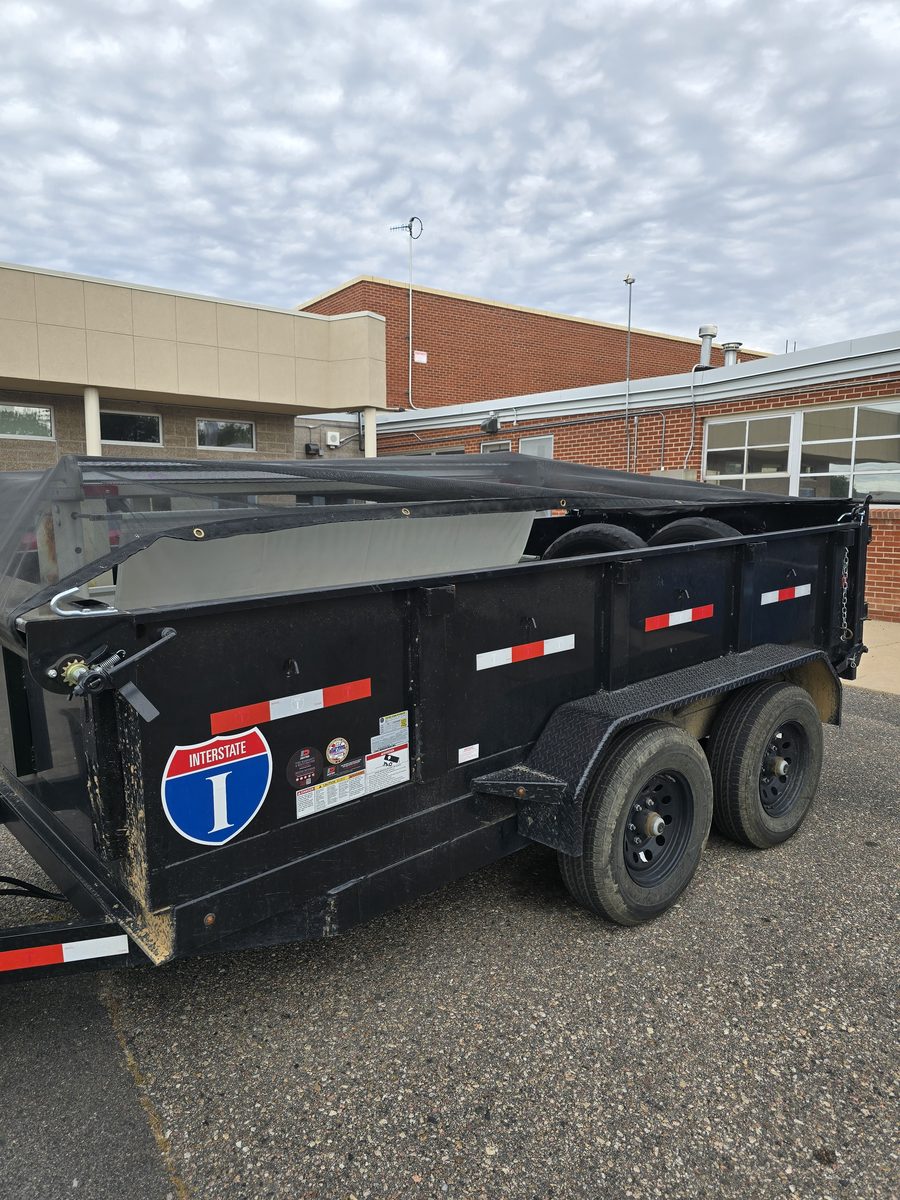 Dump trailer parked at a school for a district junk removal job in Northern Colorado