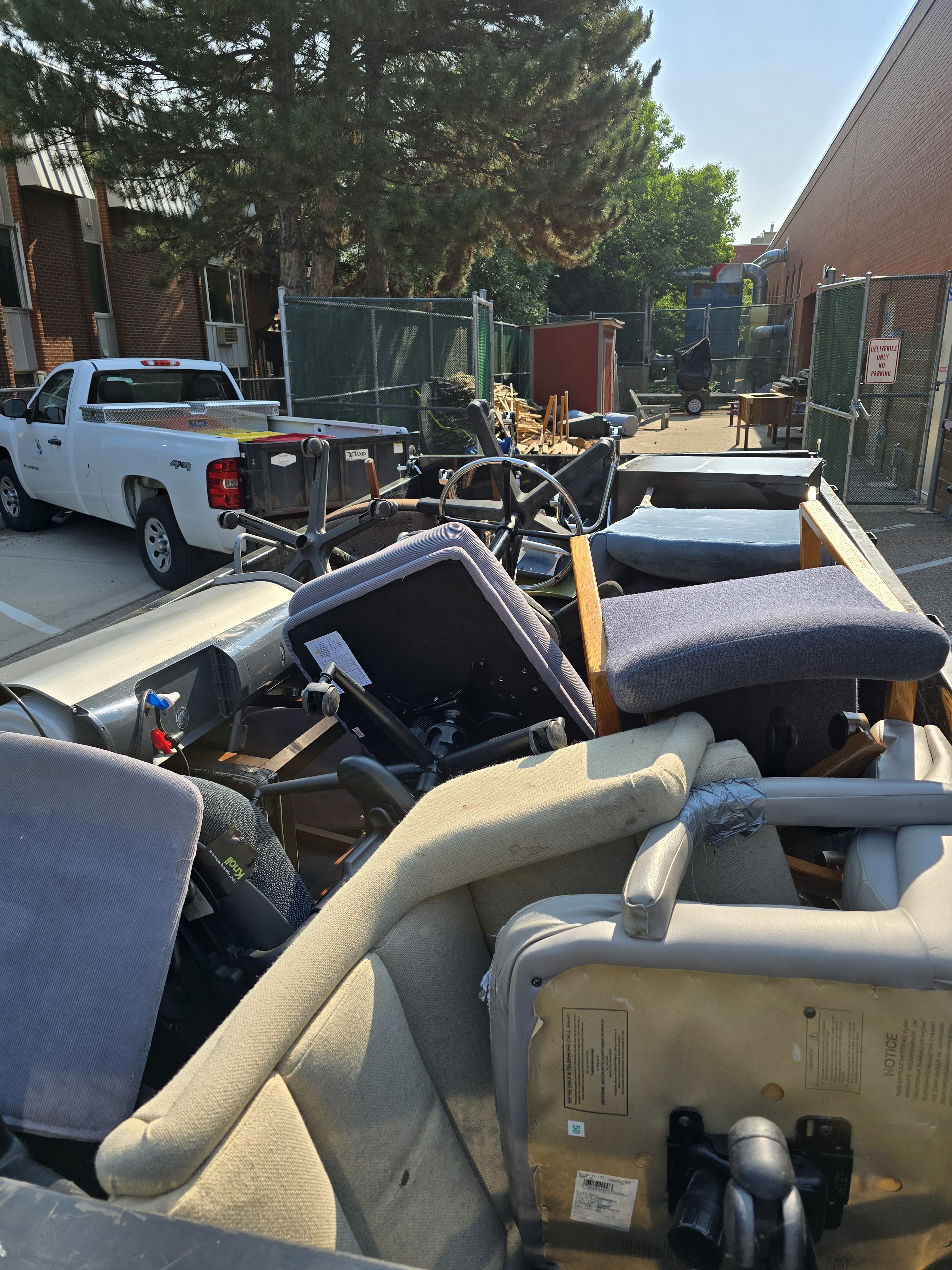 Trailer fully loaded with office chairs, monitors, and commercial furniture during a junk removal job in Northern Colorado
