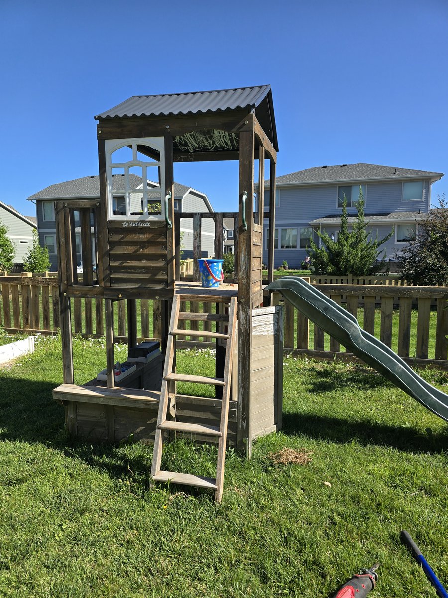 Old wooden playset in backyard before removal in Northern Colorado