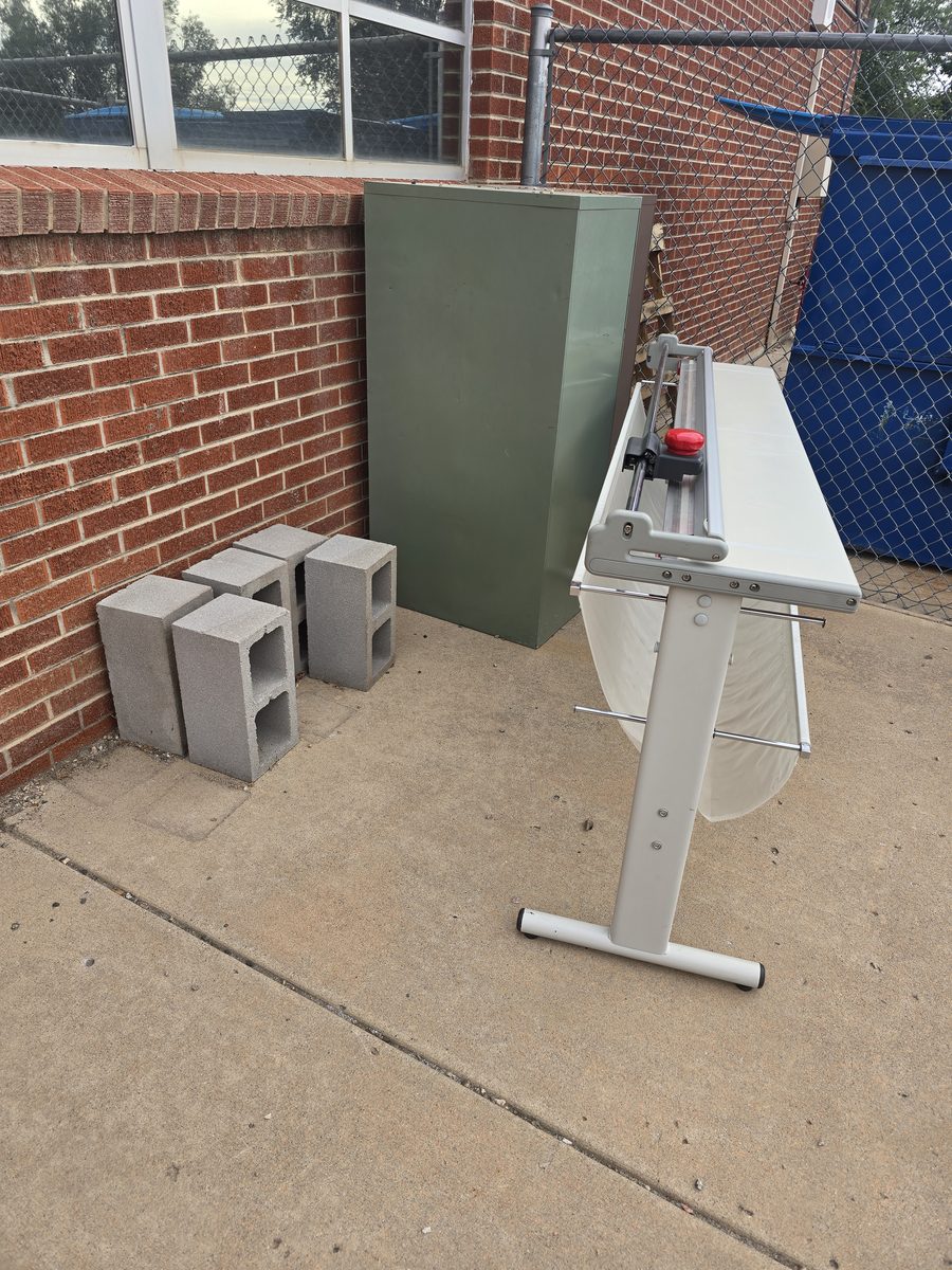 Surplus cabinets and equipment staged for removal outside a school building in Northern Colorado
