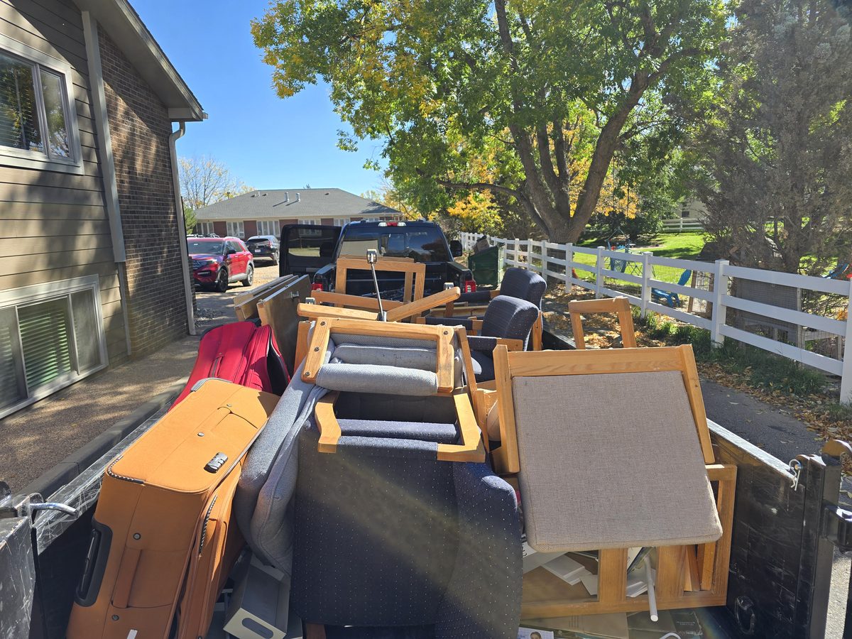 Trailer loaded with office chairs and suitcases during a commercial junk removal job in Northern Colorado
